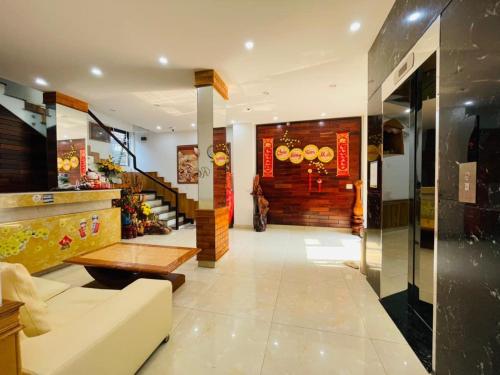 eine Lobby eines Restaurants mit einem Sofa und einem Tisch in der Unterkunft Ngọc Bích Home Huế in Hue