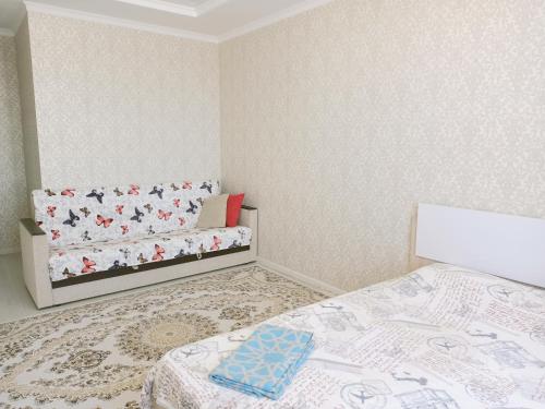 a small bedroom with a bed and a couch at Однокомнатная квартира в ЖК Millennium Park in Astana