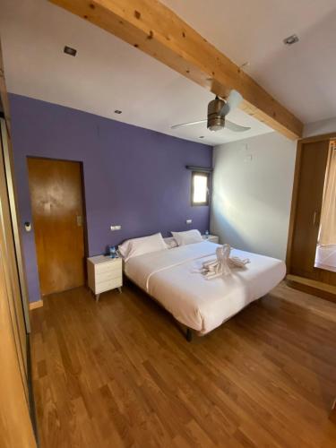sypialnia z dużym białym łóżkiem i niebieską ścianą w obiekcie El Olivar Fuerteventura Holidays w mieście Puerto del Rosario