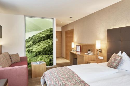 a hotel room with a bed and a large window at Hotel Donauhof in Emmersdorf an der Donau