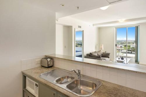a kitchen with a sink and a large mirror at Modern spacious Chatswood Apartment H1016 in Sydney