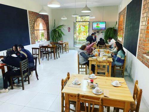 un groupe de personnes assises à table dans un restaurant dans l'établissement Alpamayo Casa Hotel - Restaurante, à Yungay
