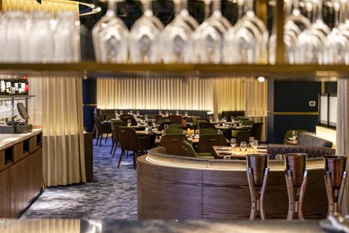 a restaurant with tables and chairs and a bar at Millennium Place Mirdif in Dubai