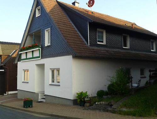 a white and black house with a brown roof at Ferienwohnung "Loni" in Benneckenstein