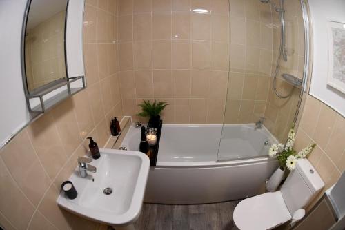 哈羅蓋特的住宿－Harrogate Self Catering - Regent's Court Azure Suite，一间带水槽、浴缸和卫生间的浴室