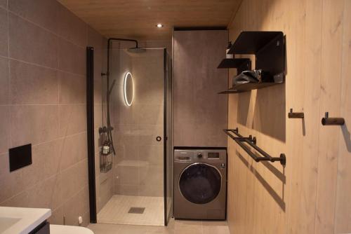 a bathroom with a shower and a washing machine at Ny leilighet på Kvitfjell Vest. Ski inn/ut in Favang