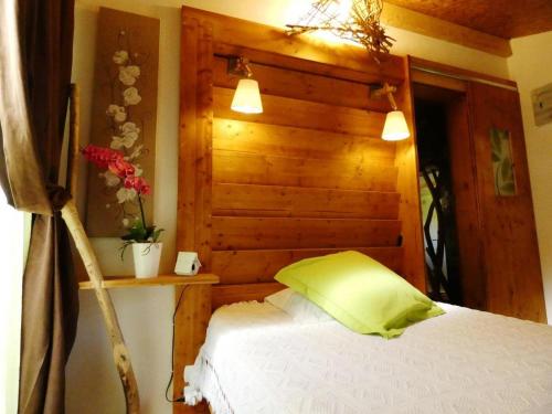 um quarto com uma cama e uma parede de madeira em Gîte l'Atelier Bois em Gaillères