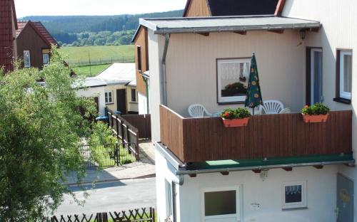 a house with a balcony with two chairs on it at Ferienwohnung Nichau in Hasselfelde