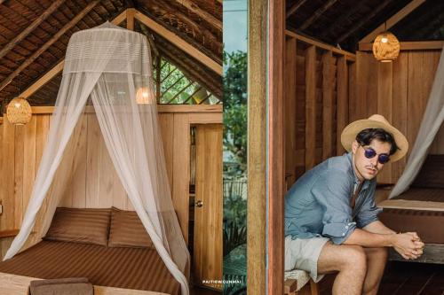 a man sitting in the inside of a house at The Tropical Koh Mook in Koh Mook