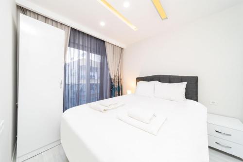 a bedroom with a white bed and a large mirror at Modern and Central Flat near Beach in Muratpasa in Antalya