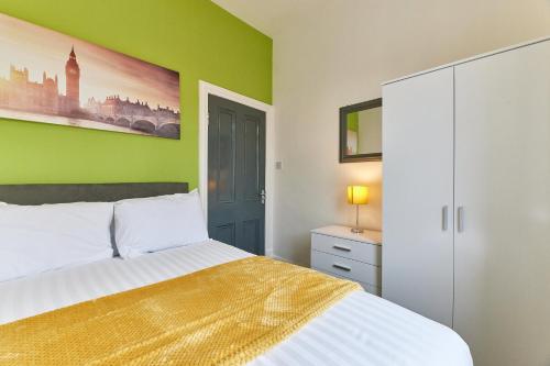 sypialnia z łóżkiem i zieloną ścianą w obiekcie Maddison House, Beautiful new renovated 5bed house w mieście Blythe