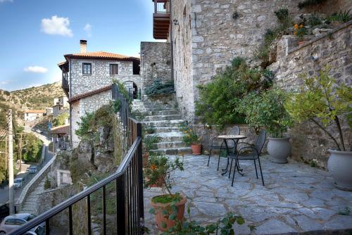 a stone staircase leading up to a building with a table at Archontiko Deligianni in Dhimitsana