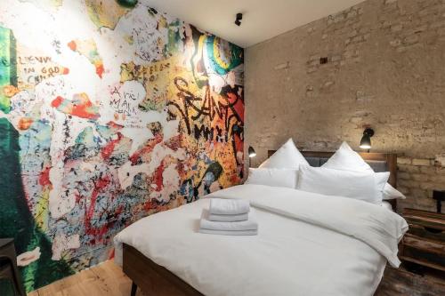 ein Schlafzimmer mit einer mit Graffiti bedeckten Wand in der Unterkunft Industrial 57sqm 3room maisonette apt near center in Berlin