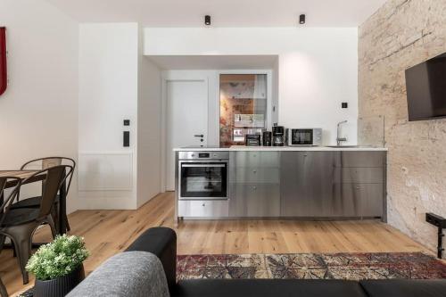 eine Küche mit Küchengeräten aus Edelstahl und ein Wohnzimmer in der Unterkunft Industrial 57sqm 3room maisonette apt near center in Berlin