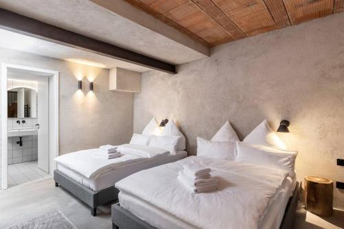 um quarto com 2 camas e lençóis brancos em Black White 44sqm 2room maisonette apt near center em Berlim