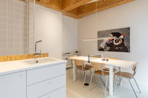 uma cozinha com um lavatório e uma mesa com cadeiras em Youngster 50sqm 4room maisonette apt near center em Berlim
