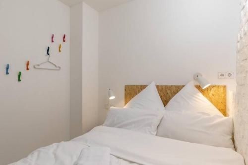 1 dormitorio con cama blanca y almohadas blancas en Youngster 50sqm 4room maisonette apt near center, en Berlín