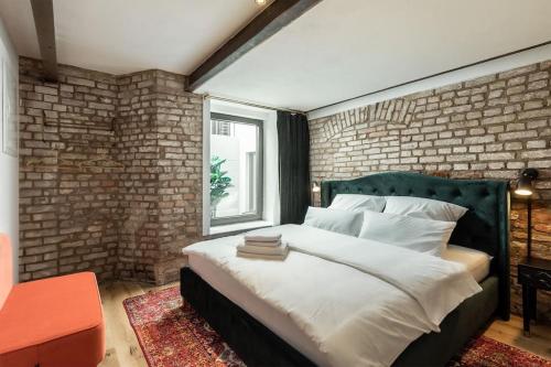een slaapkamer met een groot bed en een bakstenen muur bij Ancient 33sqm 2room maisonette apt Near center in Berlijn