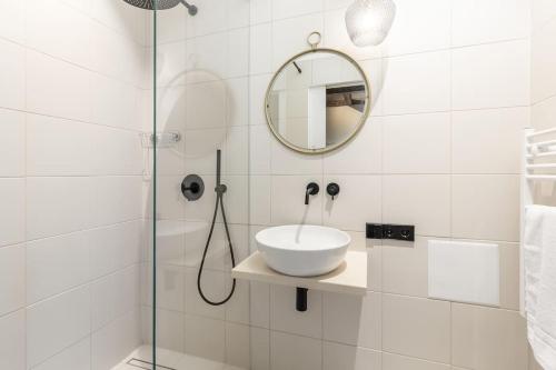 een witte badkamer met een wastafel en een douche bij Ancient 33sqm 2room maisonette apt Near center in Berlijn