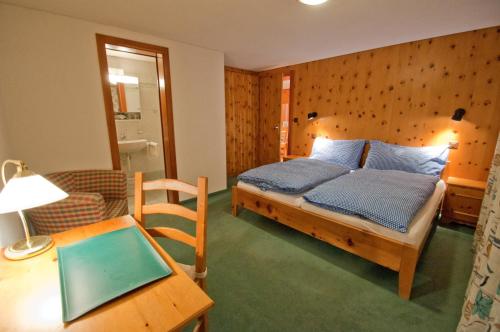 a bedroom with a bed with blue pillows and a table at Dent Blanche in Zermatt