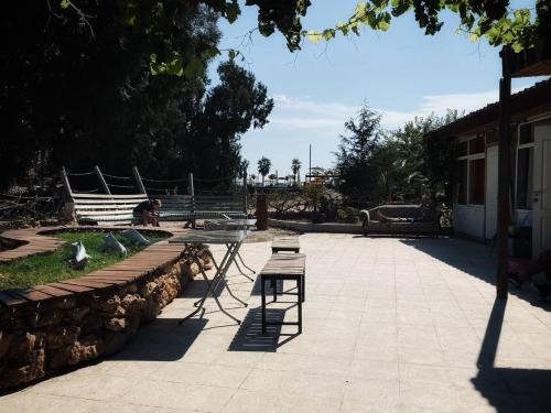 a patio with a table and a bench and some birds at CAMP&HOSTEL Antalya in Antalya