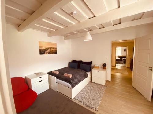 1 dormitorio con 1 cama y 1 sofá rojo en Itthon Vagy Vendégház 