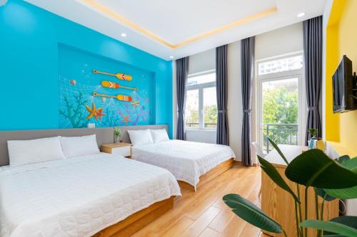 a bedroom with two beds and a fish mural at T-Maison Boutique Villa, with Pool, Karaoke, Billiards, near beach, Vung Tau in Vung Tau