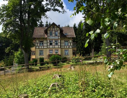 ein großes Haus mitten auf einem Feld in der Unterkunft Haus Sonnenblick in Benneckenstein