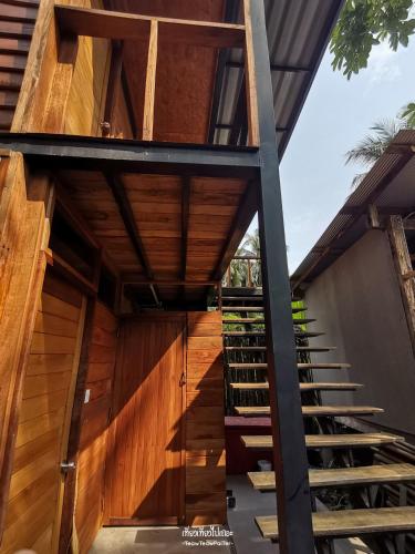 a staircase leading up to a house with wooden walls at The Tropical Koh Mook in Koh Mook