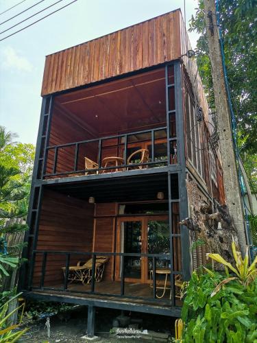 a house with a wrap around porch and a balcony at The Tropical Koh Mook in Koh Mook