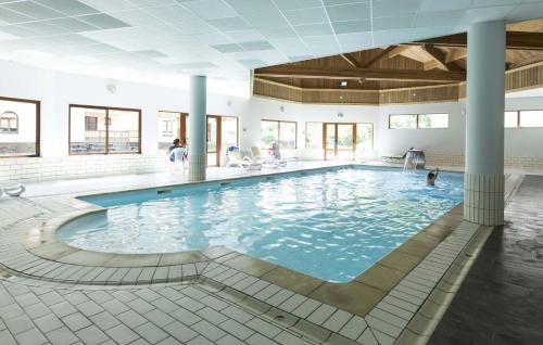 une piscine dans un bâtiment avec des gens dans l'eau dans l'établissement travelski home select - Résidence L'Orée des Pistes, à Saint-Sorlin-dʼArves