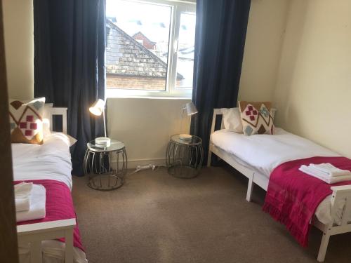a small room with two beds and a window at Luxury Town Centre Property with parking in Cheltenham