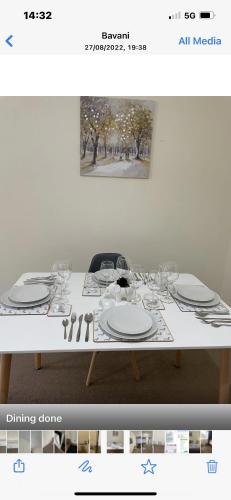 a white table with plates and wine glasses on it at Luxury Town Centre Property with parking in Cheltenham