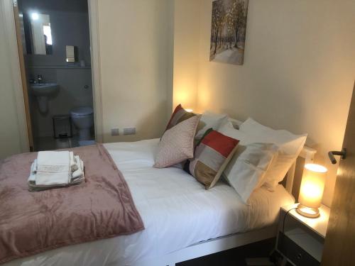 a bedroom with a bed with white sheets and pillows at Luxury Town Centre Property with parking in Cheltenham