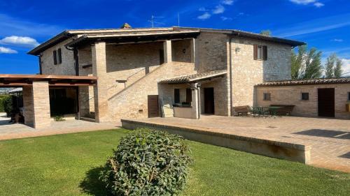 een groot bakstenen huis met een gazon ervoor bij Private pool and garden - Italian villa between Tuscany and Umbria in Limiti