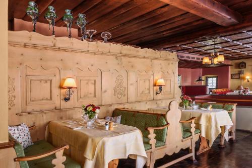 クロスタースにあるHotel Chesa Grischunaのレストラン1室(テーブル2台、椅子付)