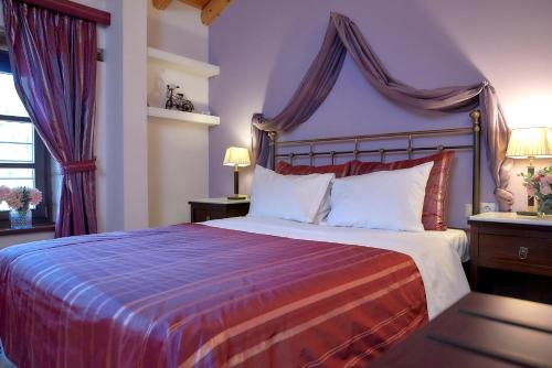 a bedroom with a large bed with a canopy at Archontiko Deligianni in Dhimitsana