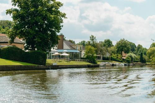a view of a river with houses in the background at Auberge du Pêcheur in Sint-Martens-Latem