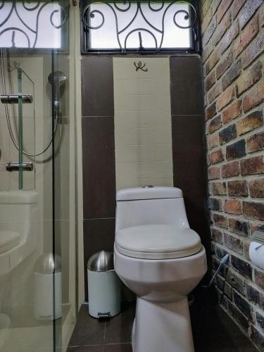 a bathroom with a toilet and a glass shower at Los Vagones de William in Tibasosa