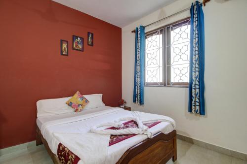 a small bedroom with a bed and a window at Hotel Raaj Inn in Calangute