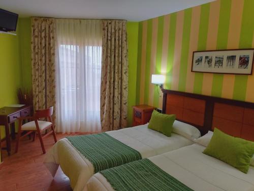 pokój hotelowy z dwoma łóżkami i biurkiem w obiekcie Hotel Rural Venta Del Alon w mieście Villalón de Campos