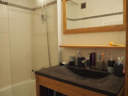 une salle de bain avec un lavabo et une baignoire dans l'établissement travelski home classic - Résidence Les Balcons d'Olympie, aux Menuires