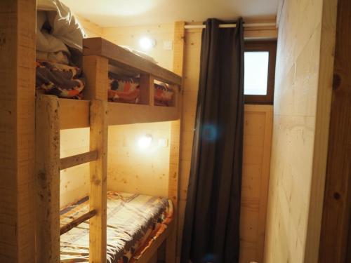 Ce lit superposé se trouve dans un dortoir doté d'une fenêtre. dans l'établissement travelski home classic - Résidence Les Balcons d'Olympie, aux Menuires