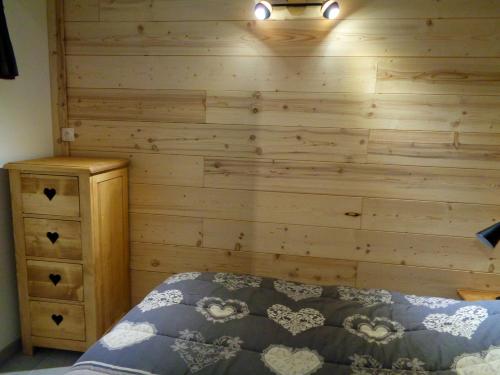 a bedroom with a wooden wall with a bed and a dresser at Appartement de 4 chambres a Les Deux Alpes a 100 m des pistes avec jardin clos et wifi in Les Deux Alpes