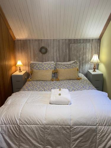 a bedroom with a large bed with a white towel on it at Gite de la Baie Hatée in Bic