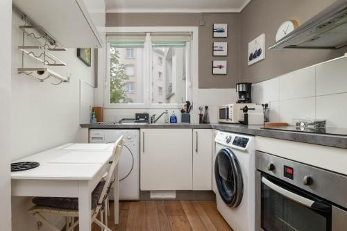 a kitchen with a washing machine and a table at Brest : charmant appartement hypercentre in Brest