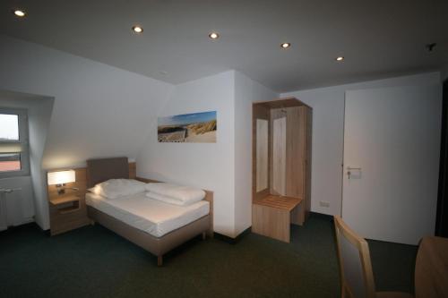 una camera con letto, tavolo e specchio di BusinessInn.de Aparthotel Bremerhaven a Bremerhaven
