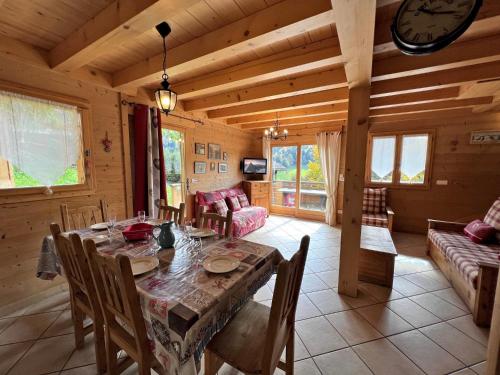 une salle à manger et un salon avec une table et des chaises dans l'établissement Aulp de Suz 2 - Chalet avec vue, à La Clusaz