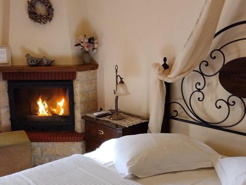 a bedroom with a bed and a fireplace at Valentini Guesthouse in Karpenision