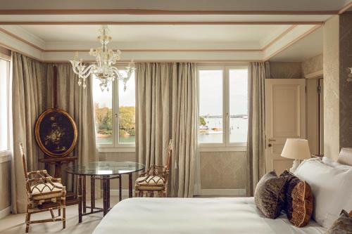 a bedroom with a bed and a table and a window at Hotel Cipriani, A Belmond Hotel, Venice in Venice